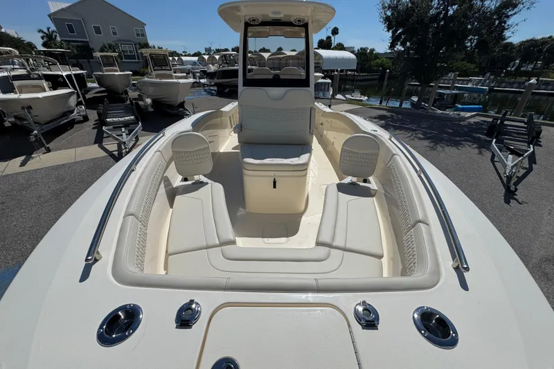 Slide: The Image of 2026 Scout 260 LXF boat interior with seating and console, docked outdoors. - 21