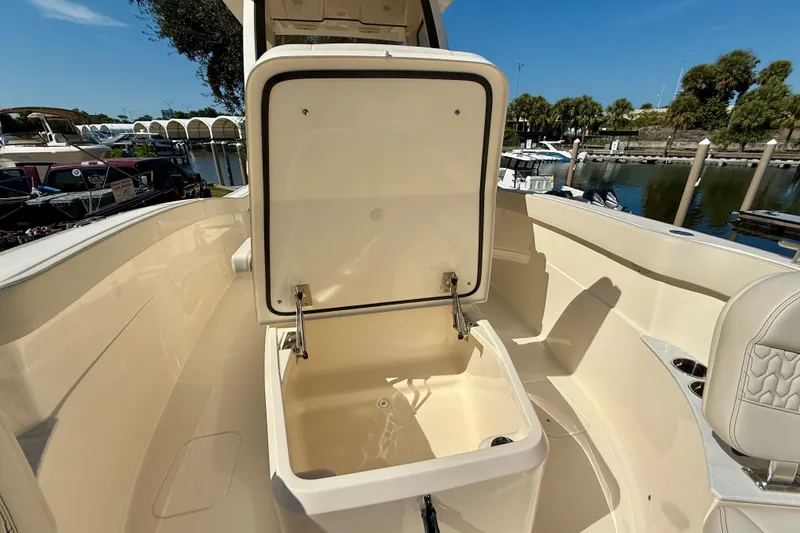 Slide: The Image of 2026 Scout 260 LXF boat with open storage compartment, docked near water. - 25