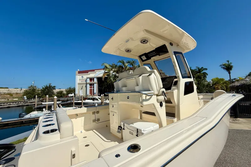 Slide: The Image of 2026 Scout 260 LXF boat docked, showcasing sleek design and spacious deck under clear blue sky. - 4