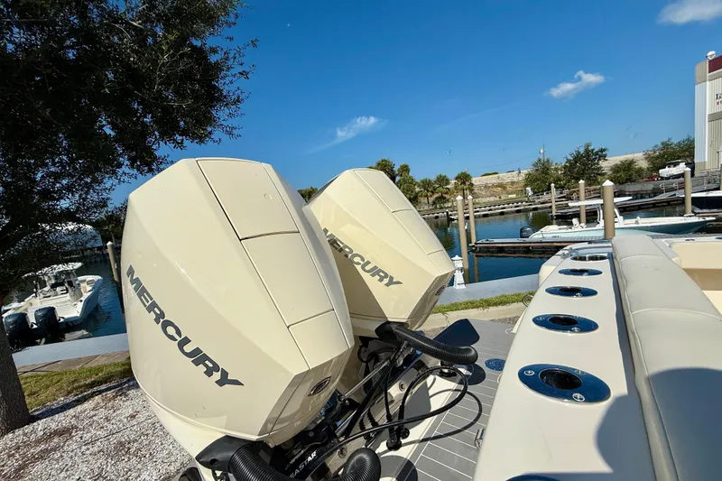 Slide: The Image of 2026 Scout 260 LXF boat with dual Mercury outboard engines at a marina. - 7