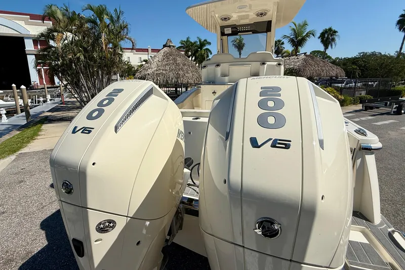 Slide: The Image of 2026 Scout 260 LXF boat with dual Mercury 200 V6 engines, docked near tropical scenery. - 8