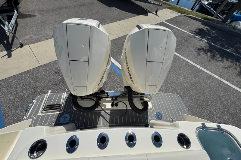 Slide: The Image of 2026 Scout 260 LXF boat with dual Mercury outboard engines, docked on a sunny day. - 9