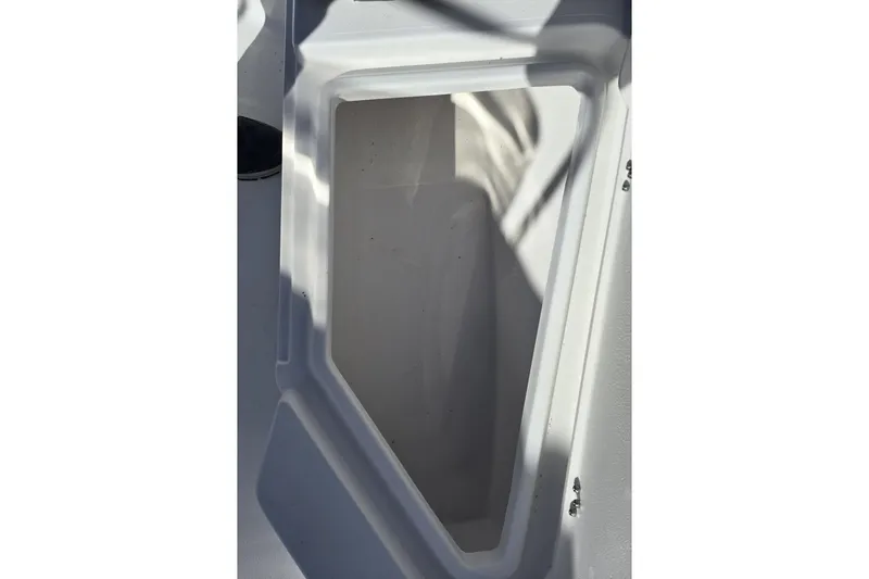 Slide: The Image of 2026 NauticStar 191 Hybrid boat storage compartment, white interior, angled view. - 13