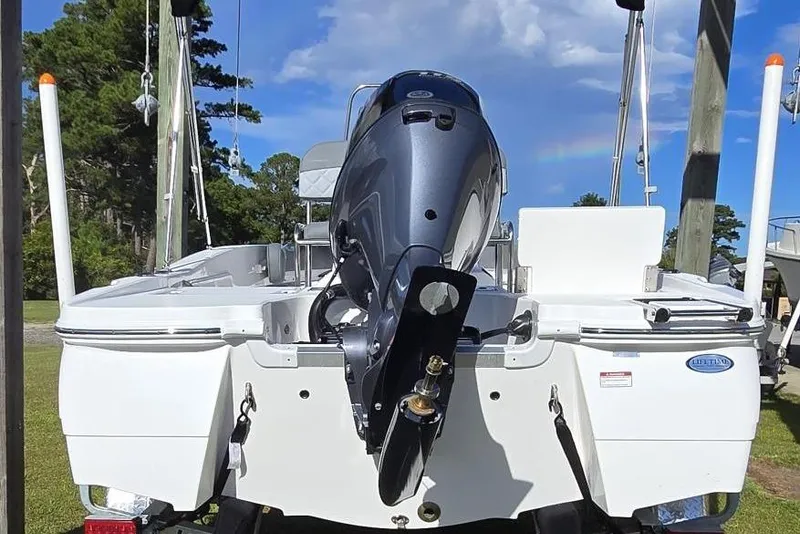 Slide: The Image of 2026 NauticStar 191 Hybrid boat with outboard motor, parked outdoors. - 2