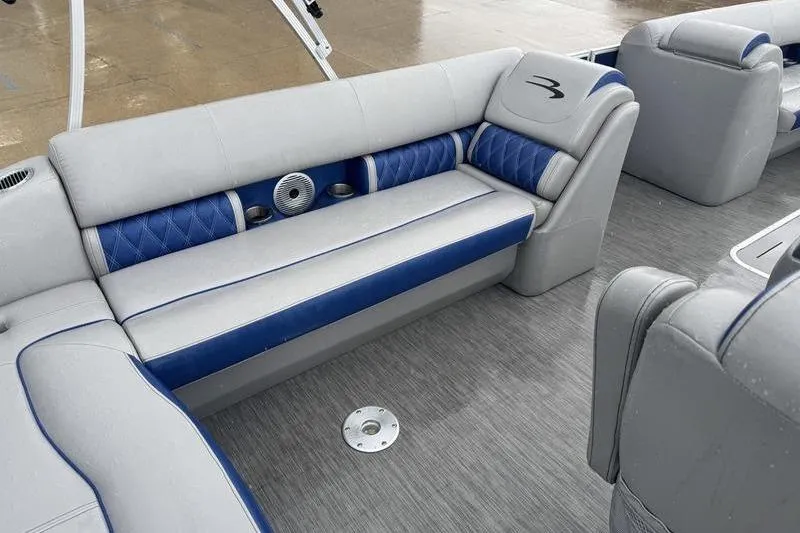 Slide: The Image of 2022 Bennington 26 LXSB boat interior with blue and gray seating, modern design. - 11
