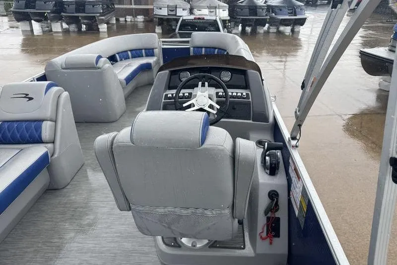 Slide: The Image of 2022 Bennington 26 LXSB pontoon boat interior with steering console and seating. - 12