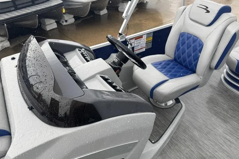 Slide: The Image of 2022 Bennington 26 LXSB boat interior with blue and gray captain's chair. - 8