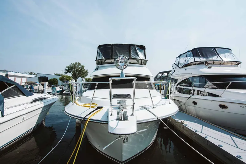 Slide: The Image of 1991 Carver 36 Aft Cabin Motor Yacht with marina view, featuring blue cushioned seating. - 1