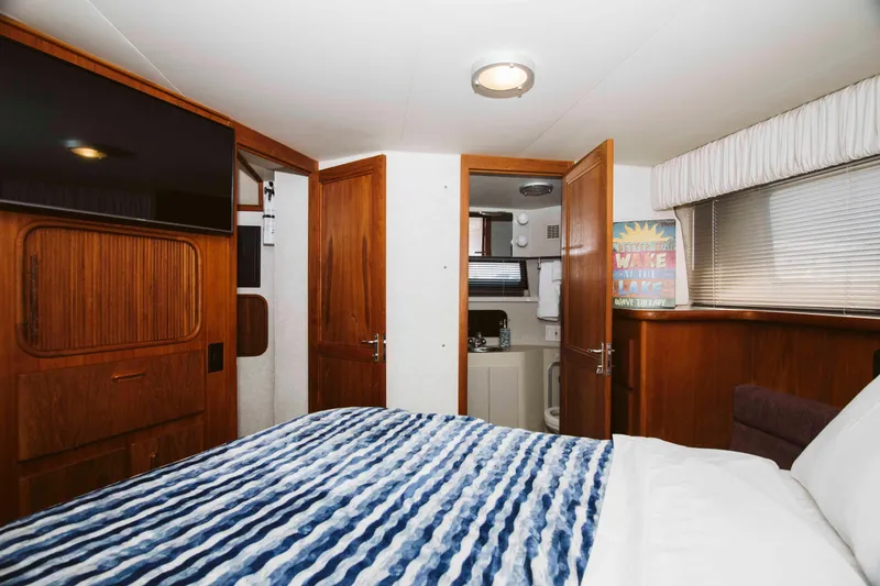 Slide: The Image of Cozy cabin interior of 1991 Carver 36 Aft Cabin Motor Yacht with striped bedding. - 15