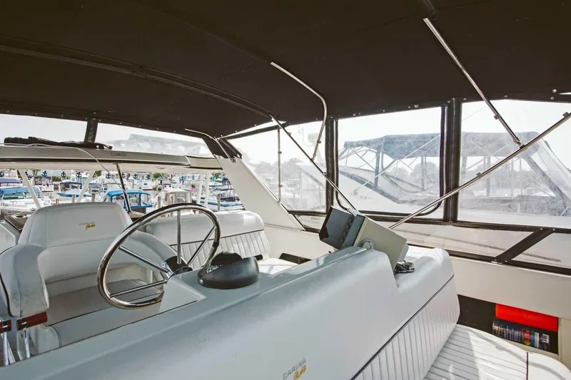 Slide: The Image of 1991 Carver 36 Aft Cabin Motor Yacht interior with white seating and helm station. - 7