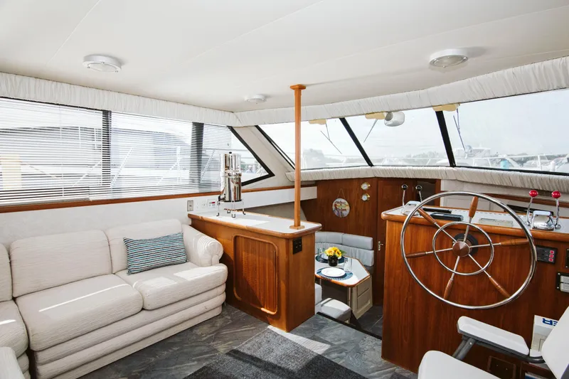 Slide: The Image of Interior of 1991 Carver 36 Aft Cabin Motor Yacht with white sofa and striped pillows. - 9