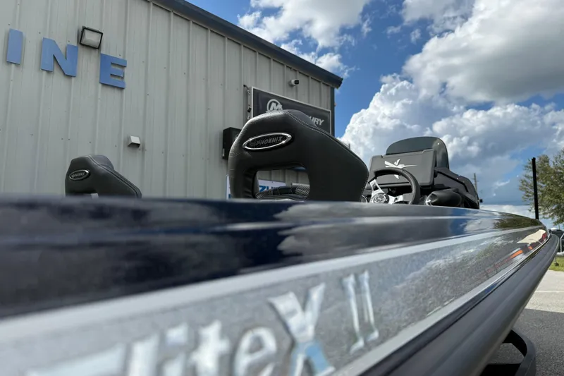 Slide: The Image of 2026 Phoenix 920 ELITE X II boat with sleek design, parked outside a building under a cloudy sky. - 17