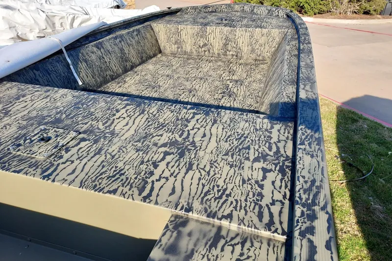 Slide: The Image of 2026 Tracker Grizzly 1648 Utility boat with camouflage pattern, parked outdoors. - 2