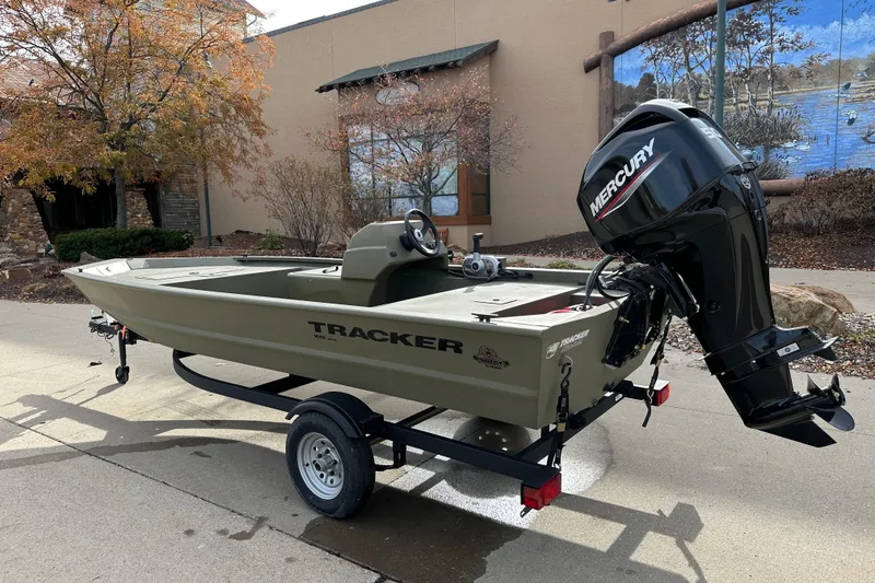 Slide: The Image of 2026 Tracker Grizzly 1648 SC boat with Mercury engine on trailer, outdoors. - 2