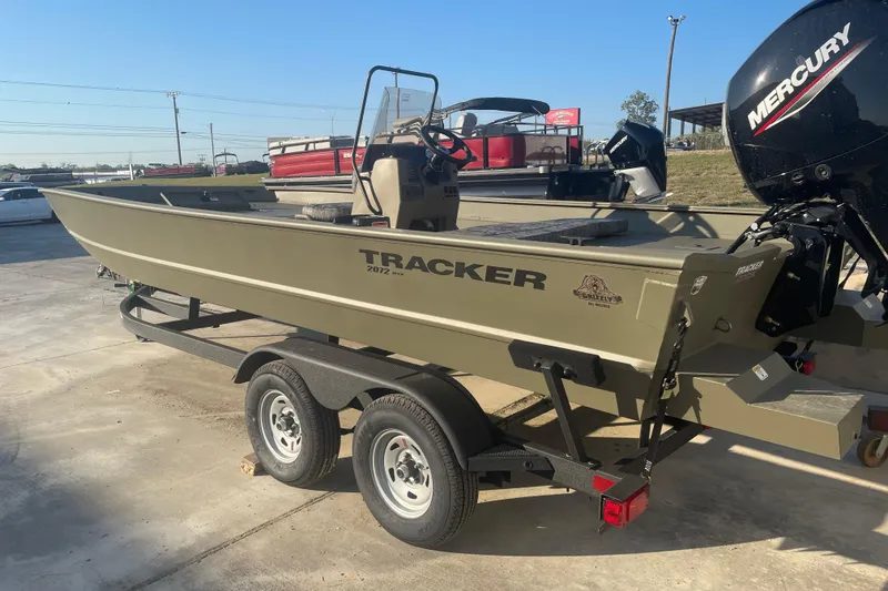 Slide: The Image of 2026 Tracker Grizzly 2072 CC boat on trailer, featuring a Mercury outboard motor. - 2