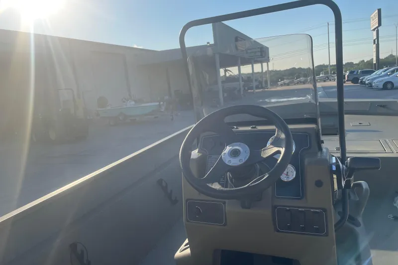 Slide: The Image of 2026 Tracker Grizzly 2072 CC boat interior with steering wheel and dashboard in sunlight. - 6