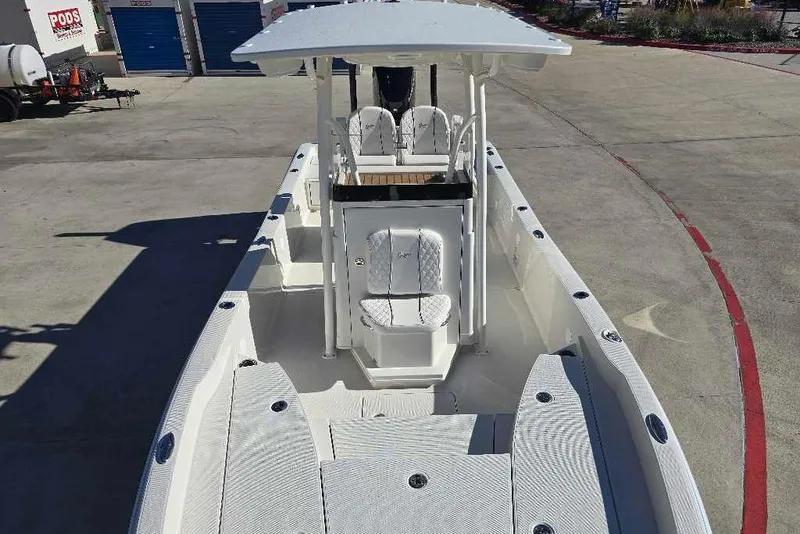Slide: The Image of 2025 Ranger 2510 Bay boat with spacious deck and seating, parked outdoors. - 13