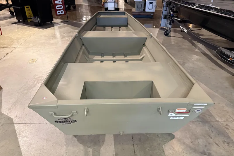 The Image of 2026 Tracker Grizzly 14 Jon boat displayed indoors, showcasing its sturdy design. - 0