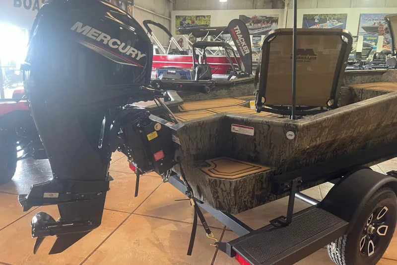 Slide: The Image of 2026 Tracker Grizzly 1650 T Prairie Wings Edition boat with Mercury outboard motor in showroom. - 3
