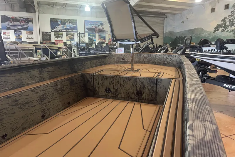 Slide: The Image of 2026 Tracker Grizzly 1650 T Prairie Wings Edition boat interior in showroom, featuring camo design. - 7