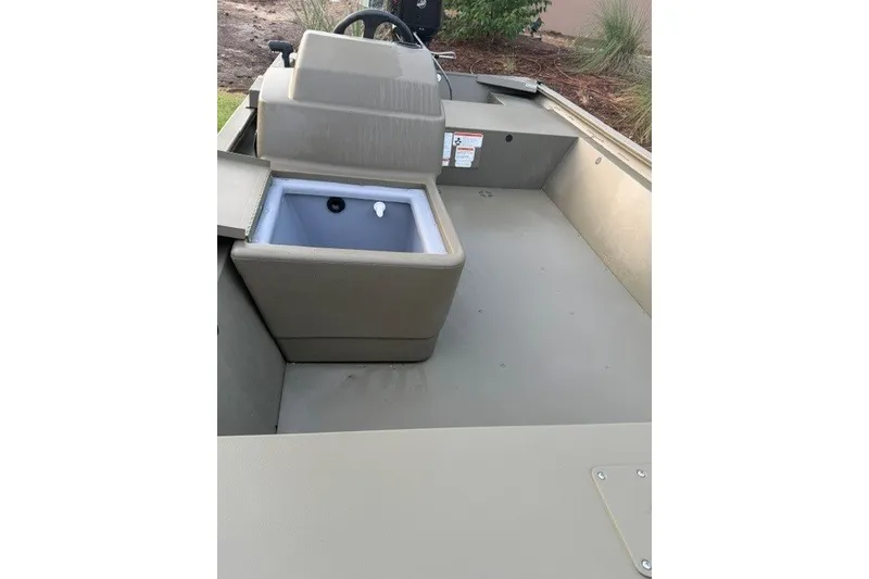 Slide: The Image of 2026 Tracker Grizzly 1648 SC boat interior with storage compartment and steering console. - 10