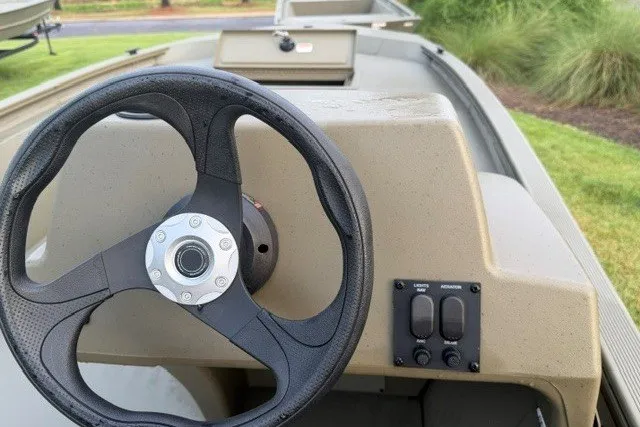 Slide: The Image of Steering wheel of 2026 Tracker Grizzly 1648 SC boat, featuring control panel and console. - 5