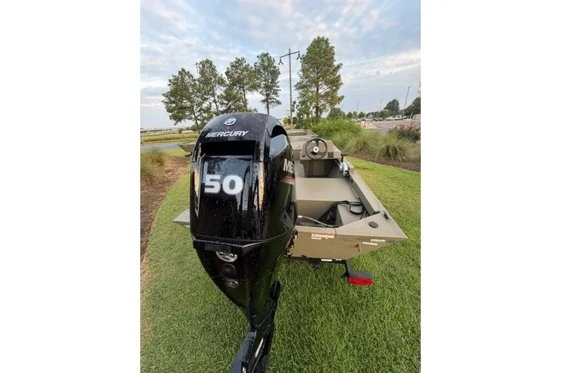 Slide: The Image of 2026 Tracker Grizzly 1648 SC boat with Mercury 50 engine on grassy area. - 4