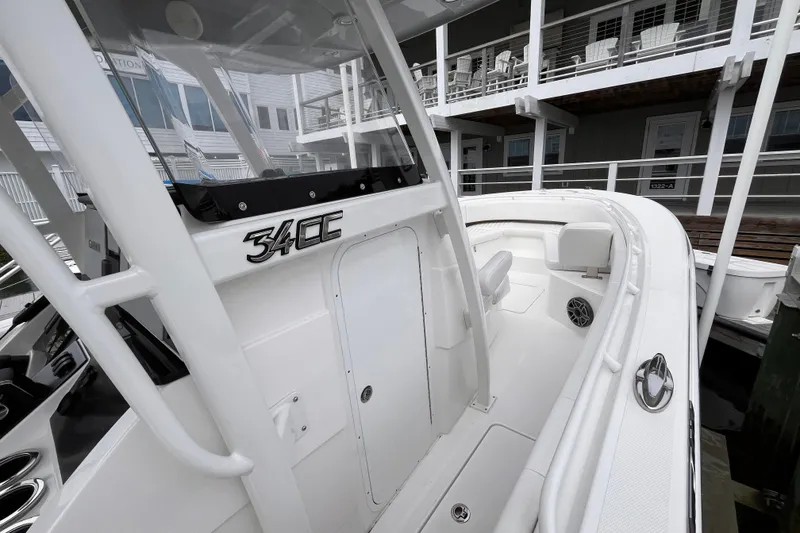 Slide: The Image of 2025 Fountain 34 CC boat, sleek white design, docked near modern building. - 11