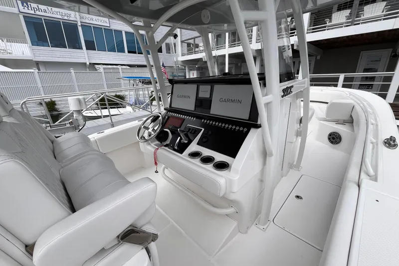 Slide: The Image of 2025 Fountain 34 CC boat interior with Garmin navigation system and white seating. - 12