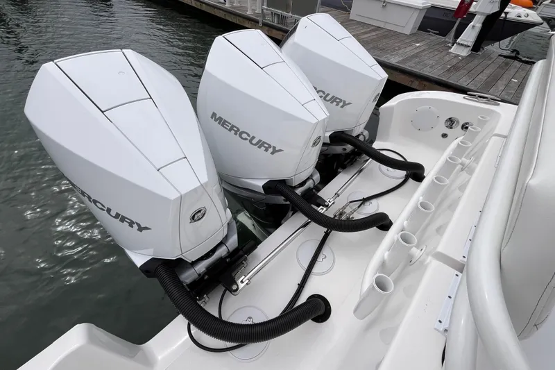 Slide: The Image of Triple Mercury outboard engines on a 2025 Fountain 34 CC boat docked by the water. - 15