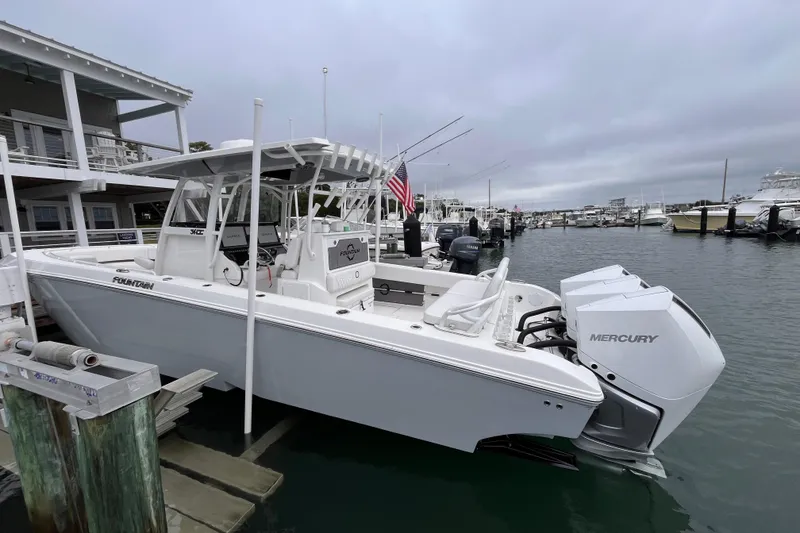 Slide: The Image of 2025 Fountain 34 CC boat docked with twin Mercury engines in a marina. - 3