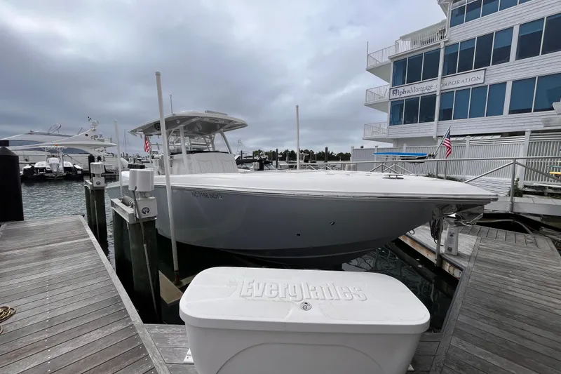 Slide: The Image of 2025 Fountain 34 CC boat docked at marina with overcast sky. - 6