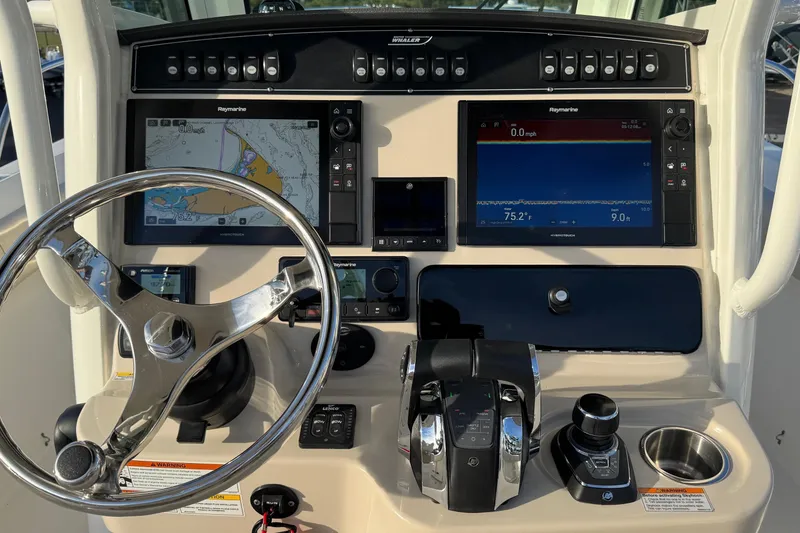 Slide: The Image of Control panel of a 2021 Boston Whaler 280 Outrage with navigation screens and steering wheel. - 13