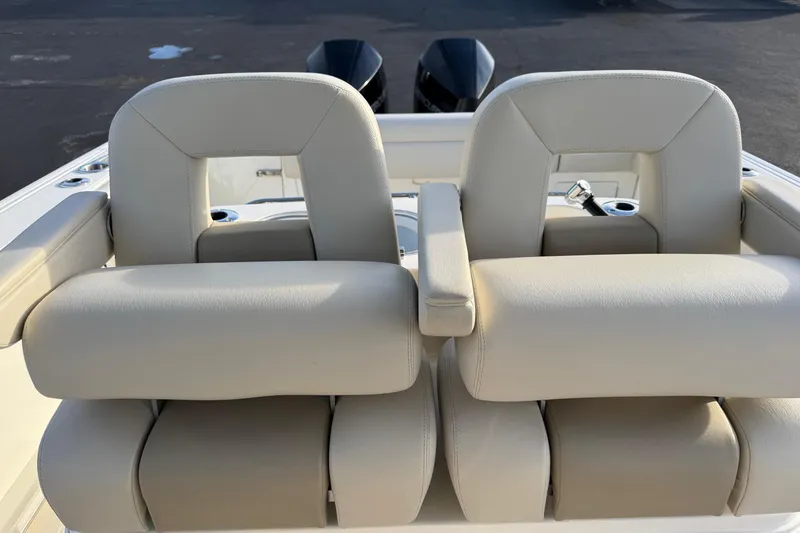 Slide: The Image of 2021 Boston Whaler 280 Outrage boat seats with armrests and cup holders. - 15