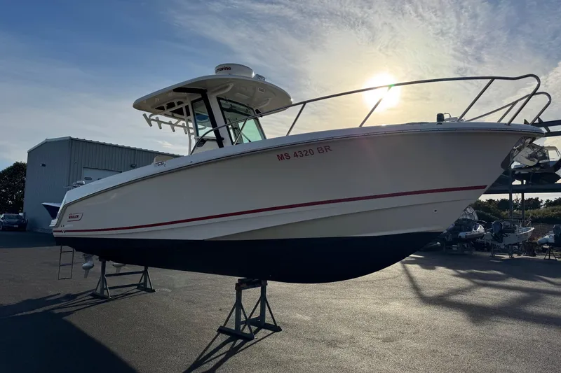 Slide: The Image of 2021 Boston Whaler 280 Outrage boat on stands, sunlit background. - 3