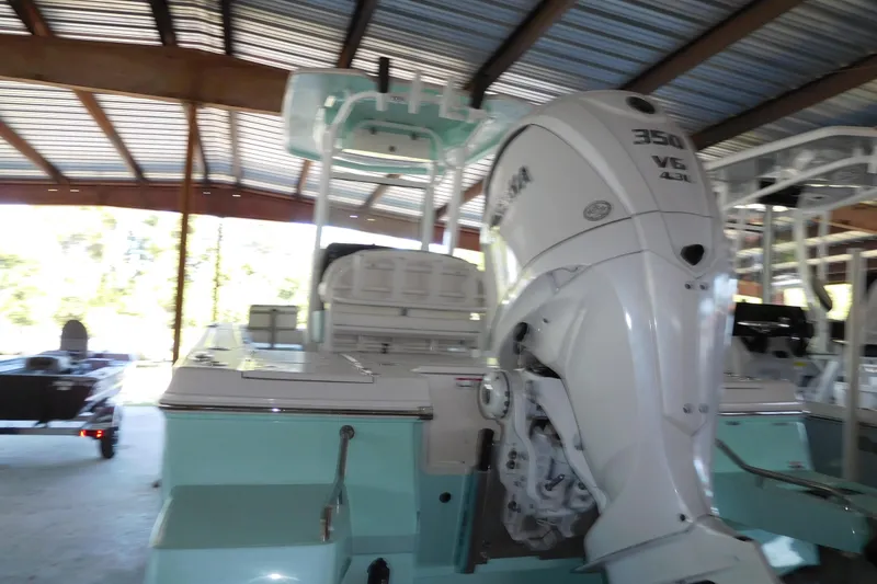 The Image of 2025 Robalo 246 Cayman boat with Yamaha 350 V6 engine in a covered storage area. - 1