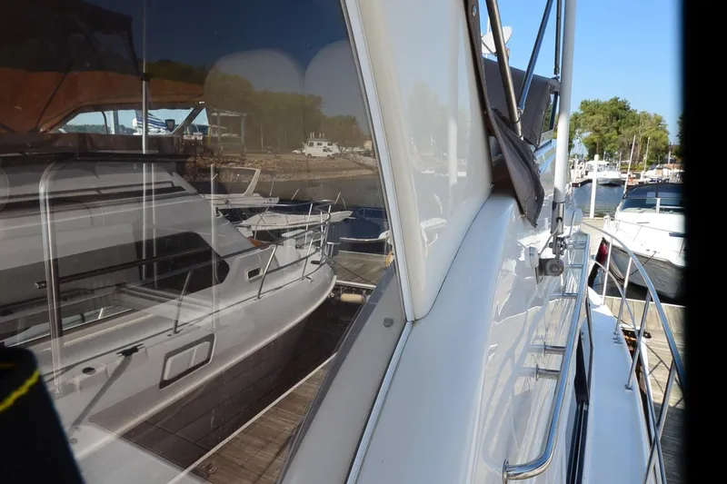Slide: The Image of 2001 Cruisers Yachts 3750 Motoryacht docked, reflecting nearby boats and marina scenery. - 17