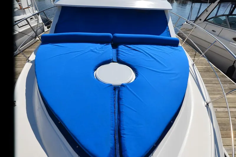 Slide: The Image of 2001 Cruisers Yachts 3750 Motoryacht with blue sunpad on deck, docked at marina. - 18