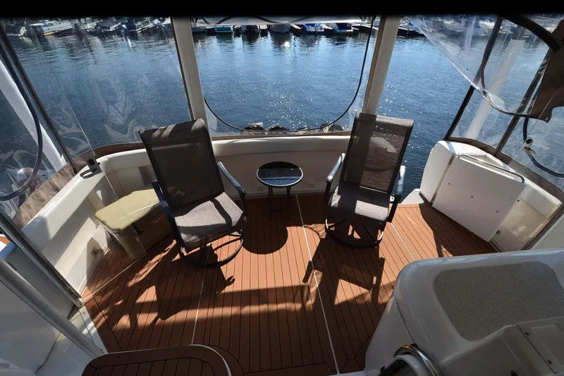 Slide: The Image of 2001 Cruisers Yachts 3750 Motoryacht deck with chairs, table, and waterfront view. - 2