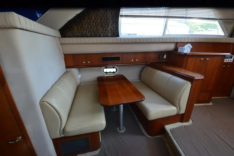 Slide: The Image of 2001 Cruisers Yachts 3750 Motoryacht interior with beige seating and wooden table. - 27