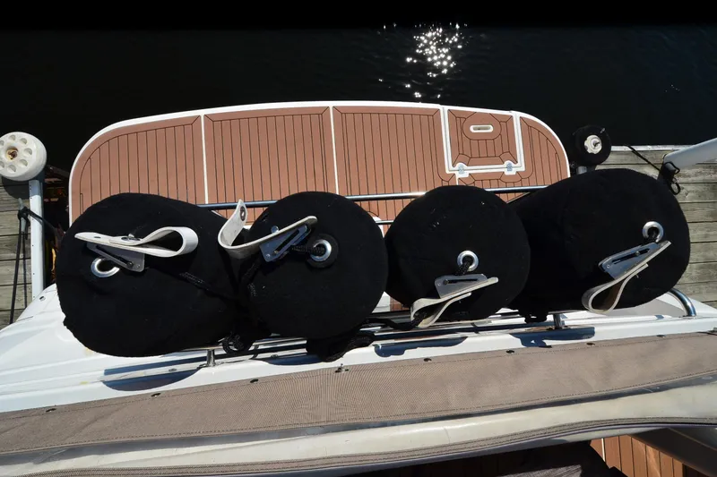 Slide: The Image of 2001 Cruisers Yachts 3750 Motoryacht with fenders on deck, docked by wooden pier. - 3