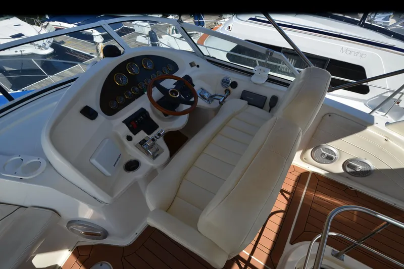 Slide: The Image of 2001 Cruisers Yachts 3750 Motoryacht helm with leather seating and wooden steering wheel. - 40