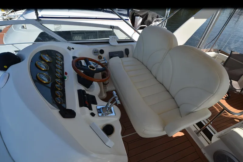 Slide: The Image of 2001 Cruisers Yachts 3750 Motoryacht helm with white seating and wooden steering wheel. - 41