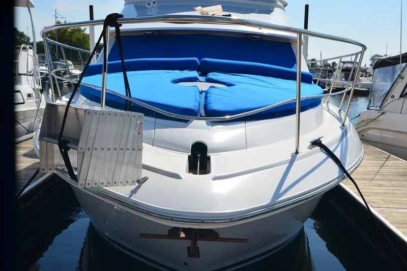 Slide: The Image of 2001 Cruisers Yachts 3750 Motoryacht docked, featuring blue sunbed and stainless steel railings. - 42