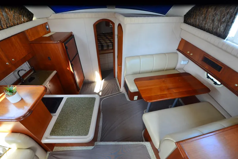 Slide: The Image of 2001 Cruisers Yachts 3750 Motoryacht interior with kitchen, dining area, and cozy seating. - 5