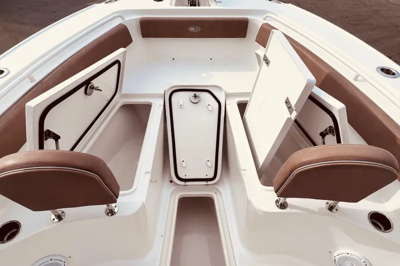 Slide: The Image of 2023 Sea Hunt Ultra 265 SE boat interior with open storage compartments and cushioned seating. - 10