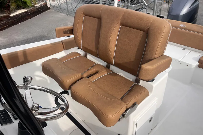 Slide: The Image of 2023 Sea Hunt Ultra 265 SE boat with brown cushioned helm seat and steering wheel. - 12