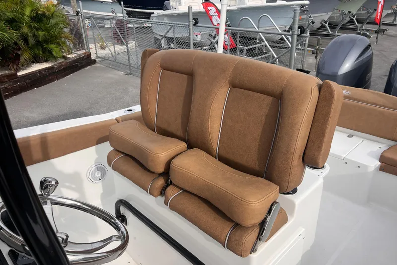 Slide: The Image of 2023 Sea Hunt Ultra 265 SE boat with brown cushioned seating and steering wheel. - 13