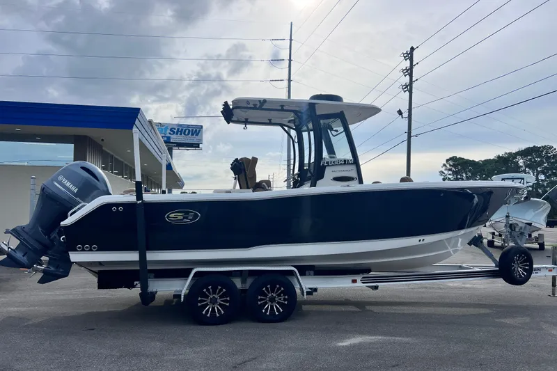 Slide: The Image of 2023 Sea Hunt Ultra 265 SE boat on trailer, side view, cloudy sky background. - 4