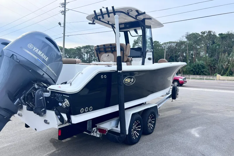 Slide: The Image of 2023 Sea Hunt Ultra 265 SE boat on trailer with Yamaha engine, parked outdoors. - 5
